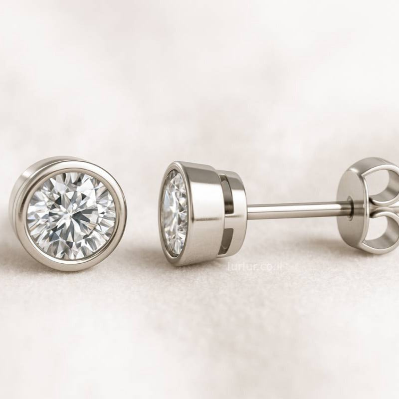 Pair of diamond stud earrings on a light background