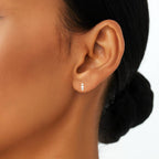 Close-up of a woman's ear with a small earring on a white background