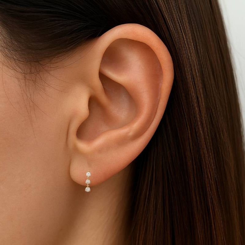 Close-up of an ear wearing a pearl earring with a blurred background