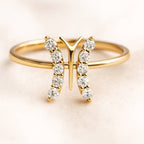 Gold ring with diamond accents on a light background
