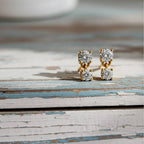 Pair of diamond stud earrings on a light wood background