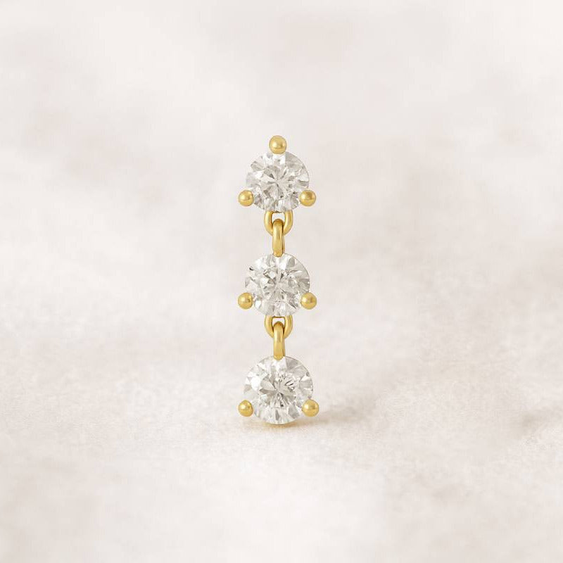 Gold and earring on a light beige background