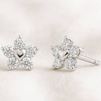 Star-shaped earrings with heart details on a light background