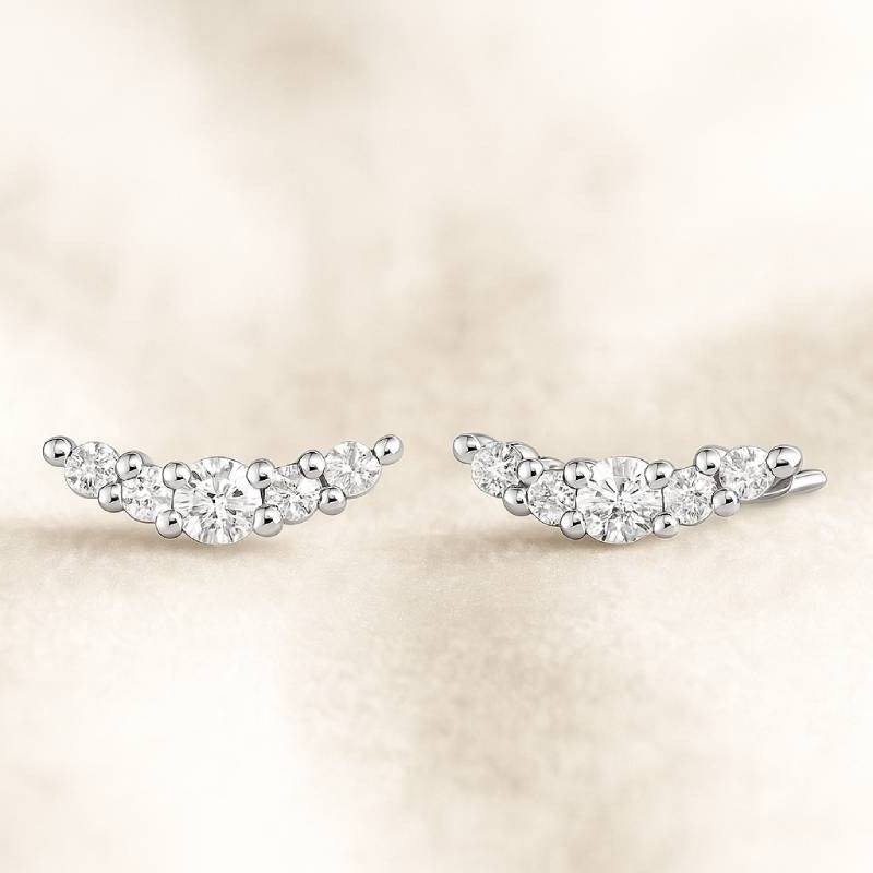 Pair of diamond earrings on a soft beige background