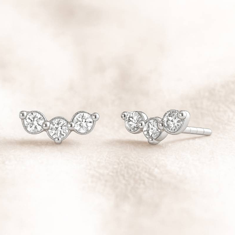 Pair of earrings with clear gemstones on a soft beige background