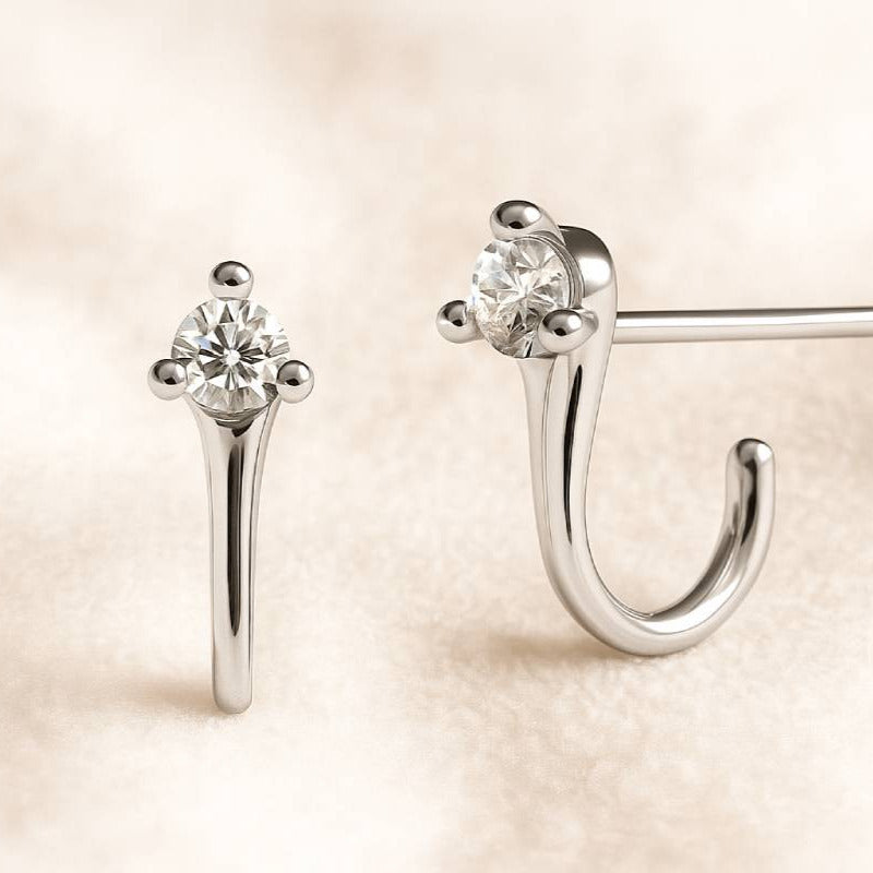 Pair of earrings with clear gemstones on a beige background