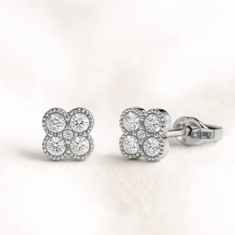 Pair of earrings with clear gemstones on a light pink background