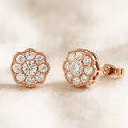 Rose gold earrings with diamond accents on a soft beige background