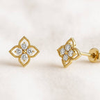 Gold earrings with diamond accents on a light background