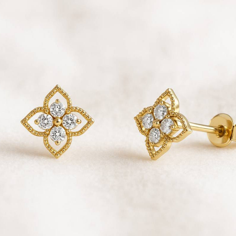 Gold earrings with diamond accents on a light background