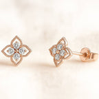 Rose gold earrings with diamond accents on a soft beige background