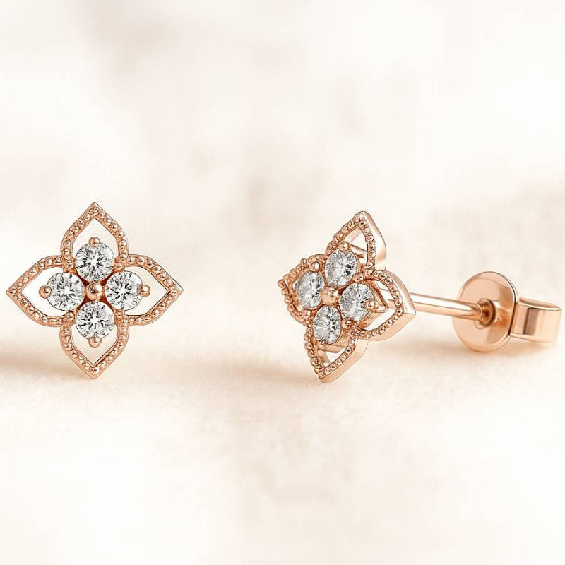 Rose gold earrings with diamond accents on a soft beige background