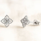 Pair of diamond earrings on a light beige background