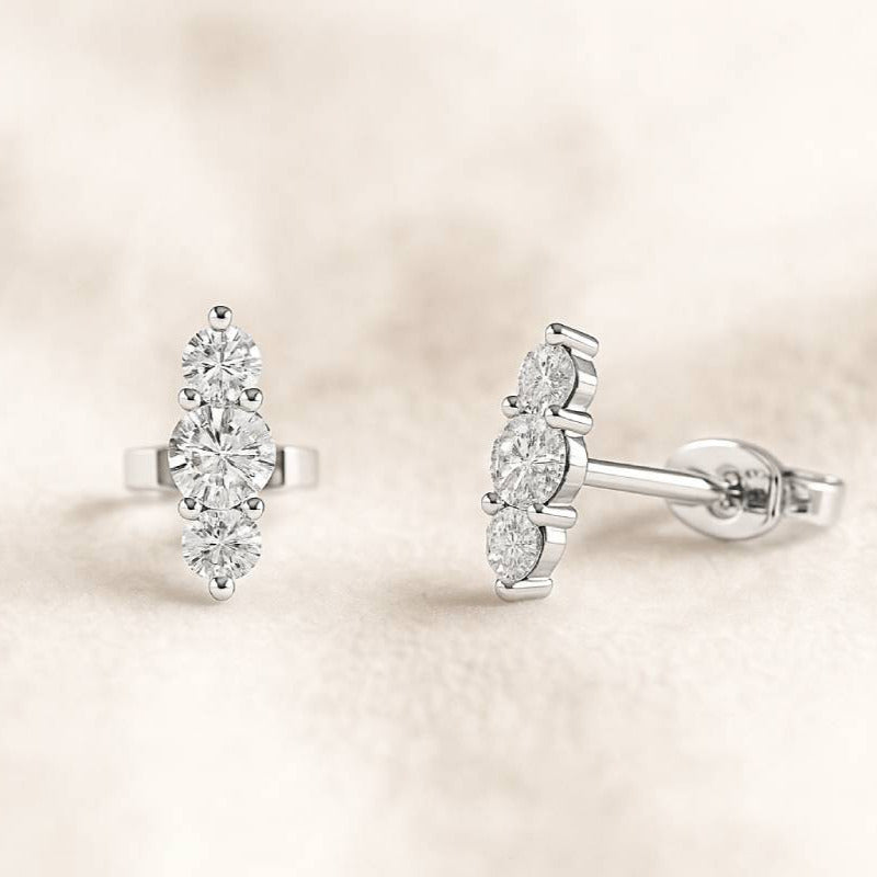 Pair of diamond earrings on a soft beige background