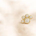 Gold earring with diamonds on a beige background
