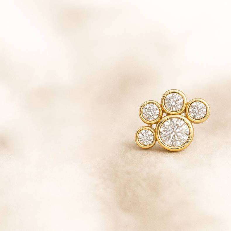 Gold earring with diamonds on a beige background