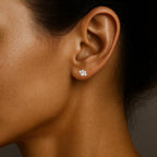 Close-up of a woman's ear wearing a diamond earring against a neutral background