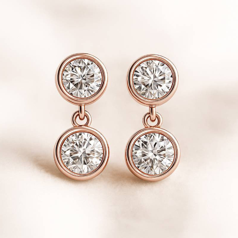 Rose gold earrings with clear gemstones on a light pink background