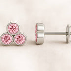 Pair of pink sapphire earrings on a light beige background