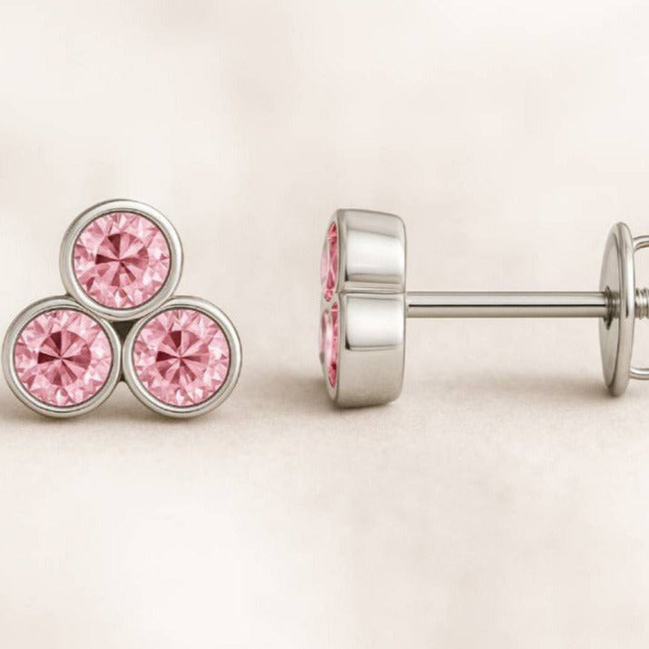 Pair of pink sapphire earrings on a light beige background