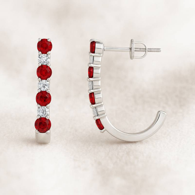 Pair of earrings with red sapphire on a beige background