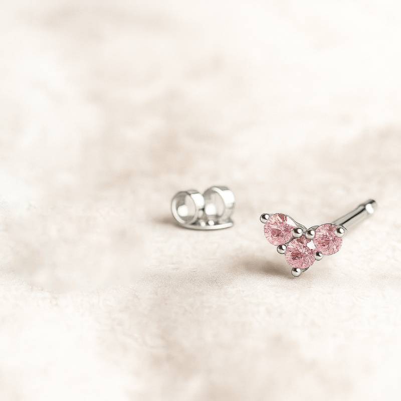 Pink gemstone stud earrings on a light pink background