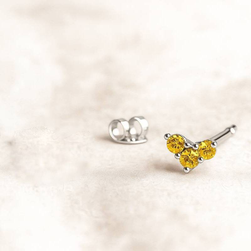  earring with yellow gemstones on a light beige background