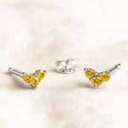 Set of gold and yellow sapphire gemstone jewelry on a beige background