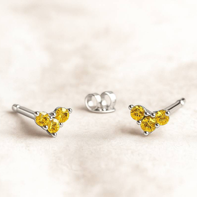 Set of gold and yellow sapphire gemstone jewelry on a beige background