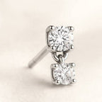 diamond stud earrings on a light beige background
