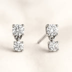 Diamond stud earrings on a light beige background