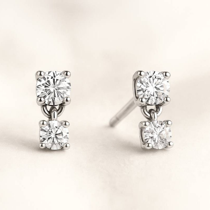 Diamond stud earrings on a light beige background