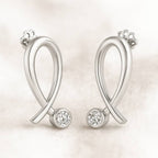 Gold earrings with diamonds on a light background