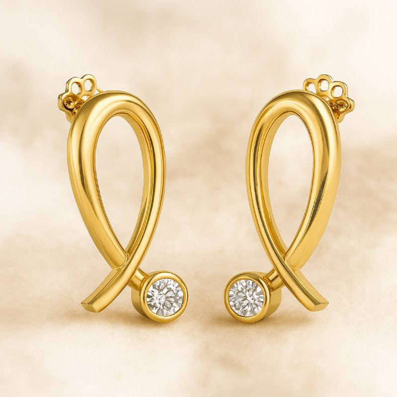 Gold earrings with diamond accents on a beige background