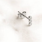 stud earrings with clear gemstones on a light pink background