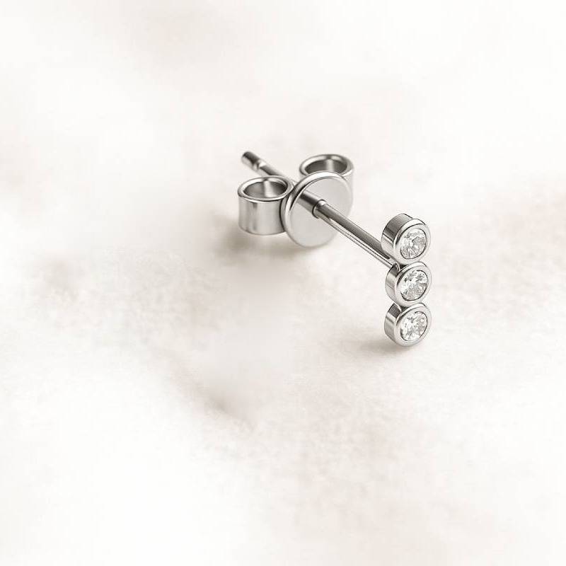 stud earrings with clear gemstones on a light pink background