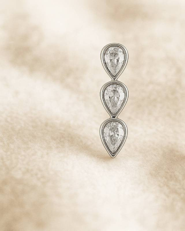 Pair of teardrop earrings on a beige textured background