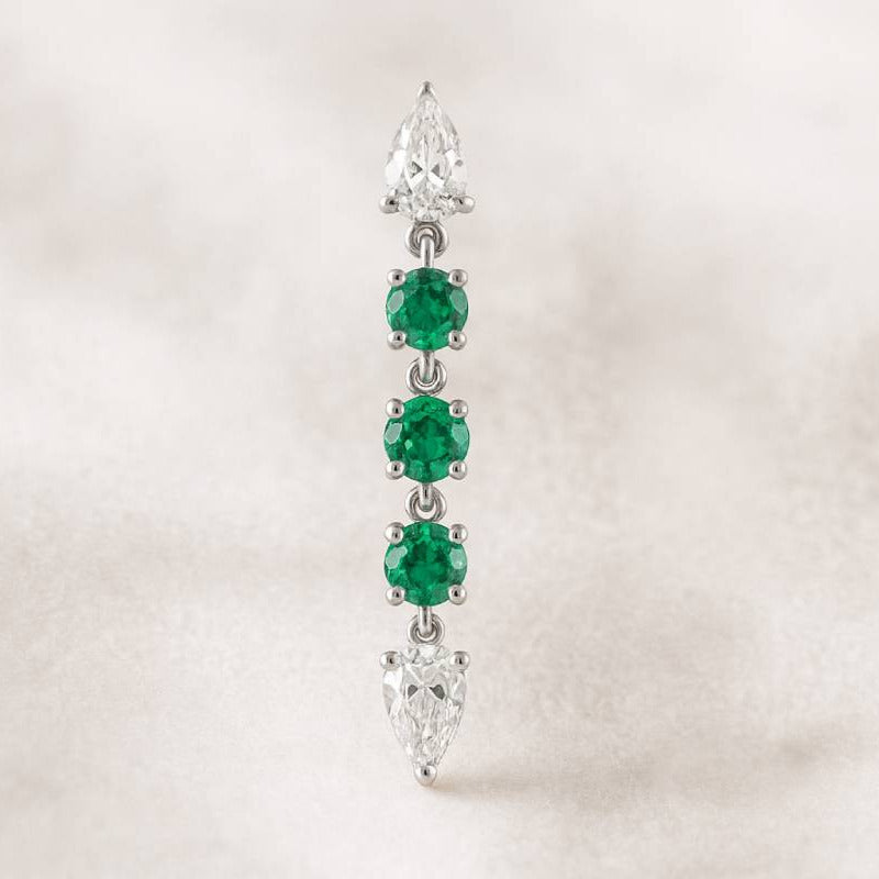 Diamond and emerald earring on a light background
