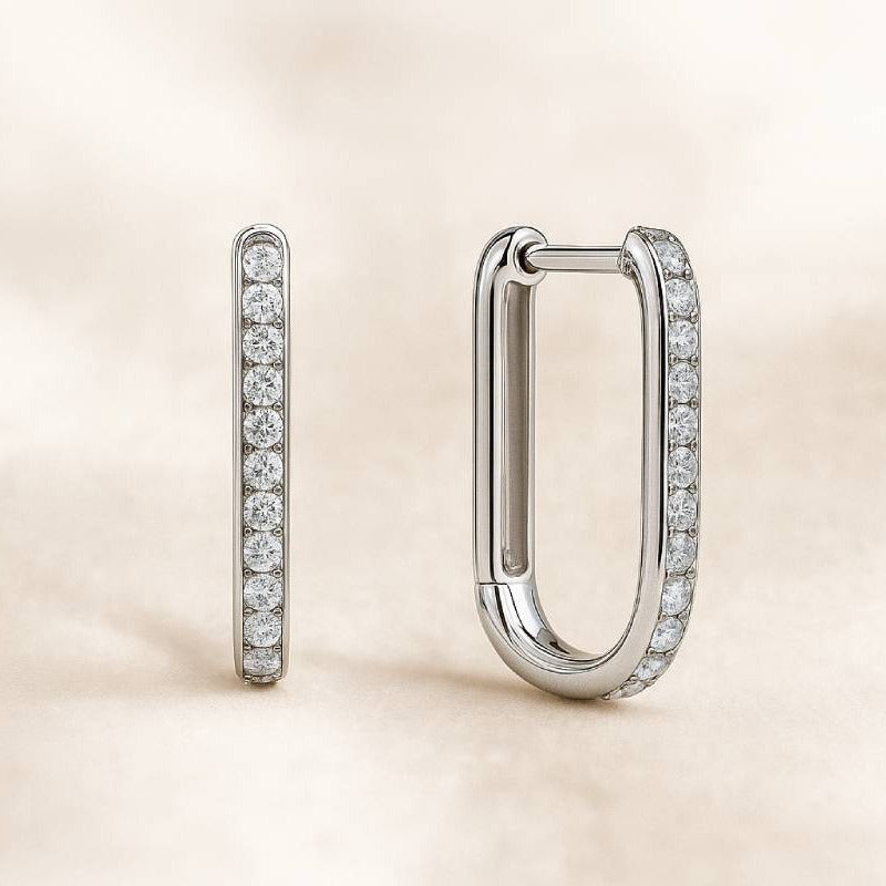 Pair of diamond hoop earrings on a beige background