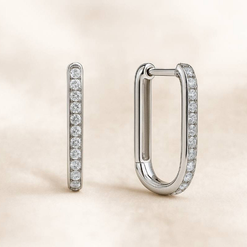 Pair of diamond hoop earrings on a beige background
