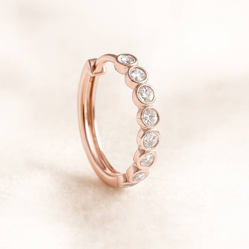 Rose gold ring with diamonds on a light beige background