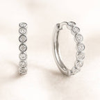 Pair of hoop earrings with embedded stones on a light background