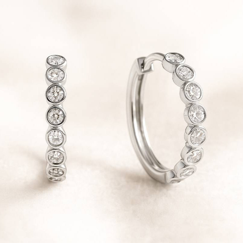 Pair of hoop earrings with embedded stones on a light background
