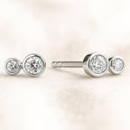 Pair of diamond stud earrings on a light background