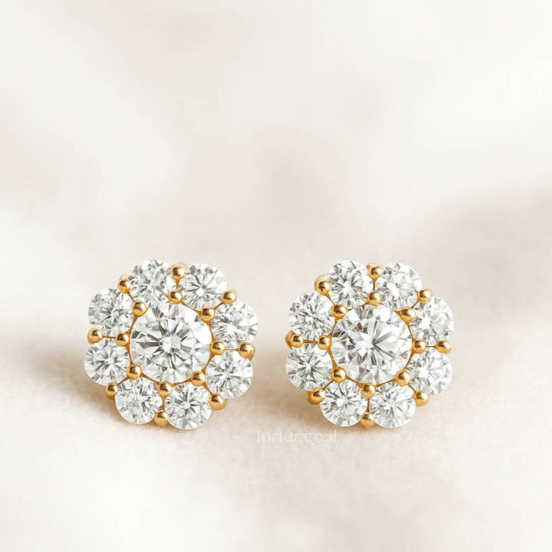 Pair of gold and crystal stud earrings on a light background