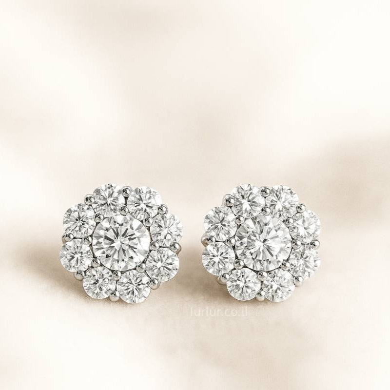 Pair of floral earrings with clear diamonds on a beige background