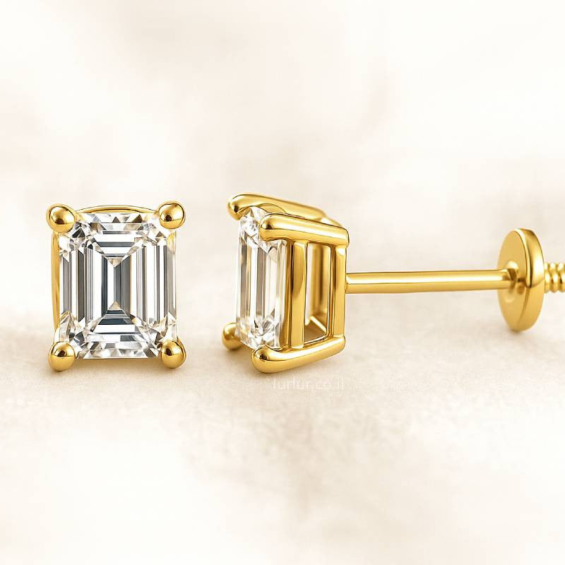 Gold emerald-cut stud earrings on a light beige background