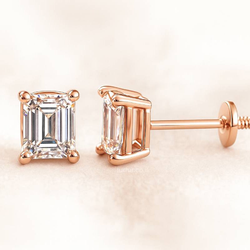 Rose gold emerald-cut earrings on a light beige background