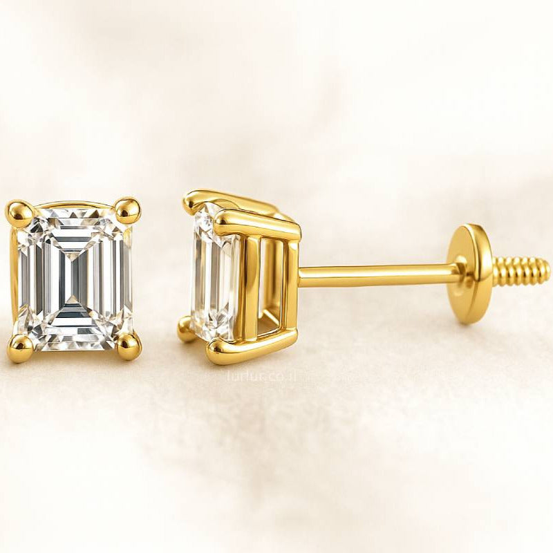 Gold emerald-cut stud earrings on a light beige background