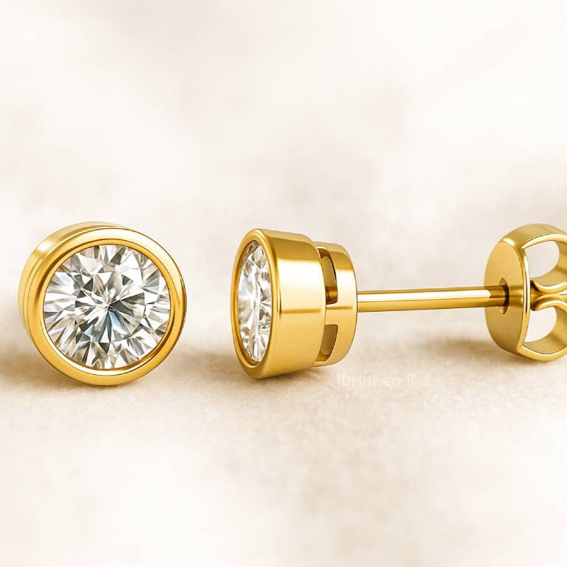 Gold diamond stud earrings on a beige background